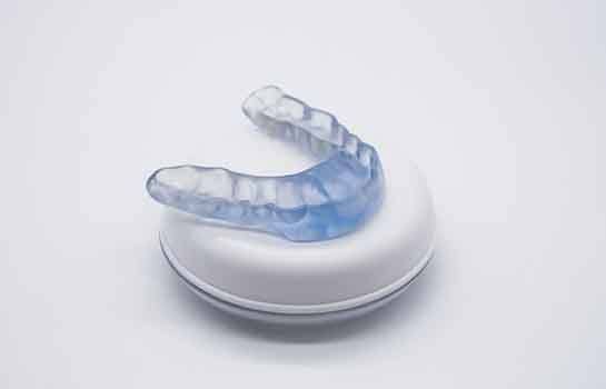 Occlusal splint resting on top of its storage container