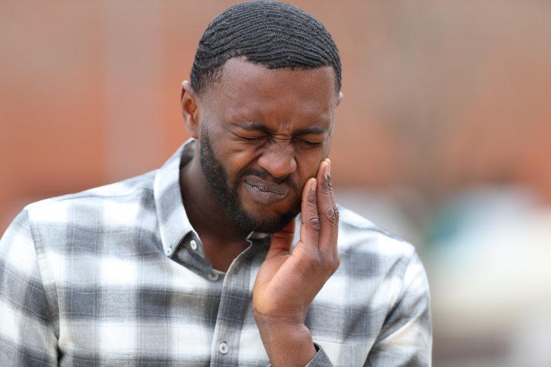 a man experiencing tooth pain while overseas