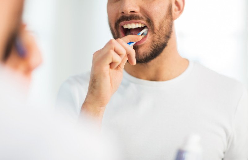 Patient brushing their teeth to prevent dental emergencies